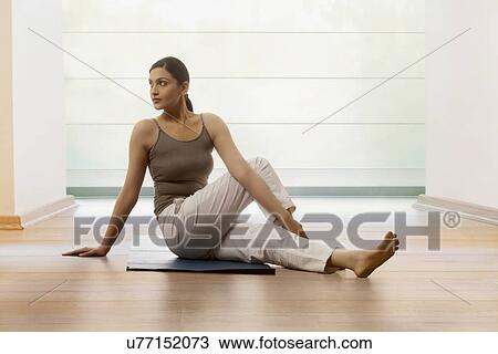 Woman doing stretching exercise on yoga mat View Large Photo Image Stock Image - Woman doing stretching exercise on yoga mat. Fotosearch