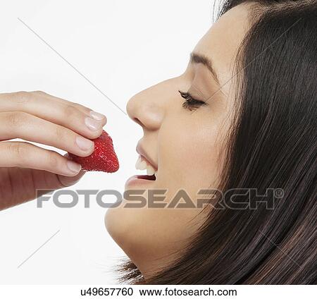 Woman eating a strawberry View Large Photo Image Stock Image - Woman eating a strawberry . Fotosearch
