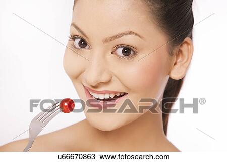 Woman eating cherry tomato on fork View Large Photo Image Stock Image - Woman eating cherry tomato on fork . Fotosearch