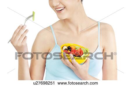 Woman eating fruits from a bowl View Large Photo Image Stock Image - Woman eating fruits from a bowl . Fotosearch