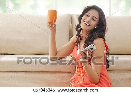 Woman enjoying while listening to music View Large Photo Image Stock Photography - Woman enjoying while listening to music. Fotosearch