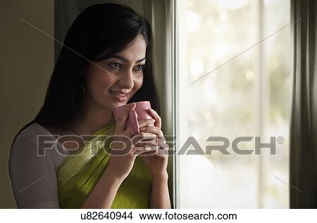 Picture - Woman having a cup of coffee . Fotosearch