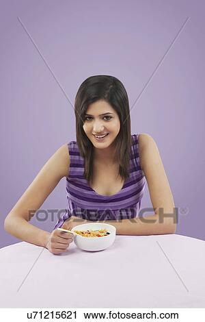 Woman having cereal for breakfast View Large Photo Image Stock Image - Woman having cereal for breakfast . Fotosearch