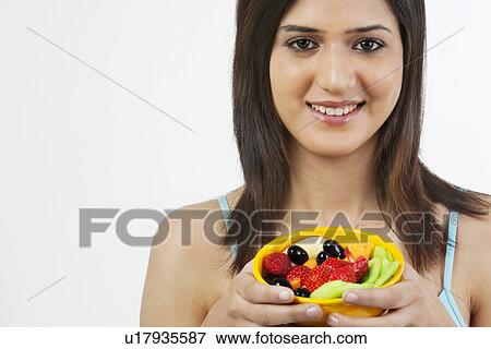 Stock Photo - Woman holding a bowl of fruits . Fotosearch