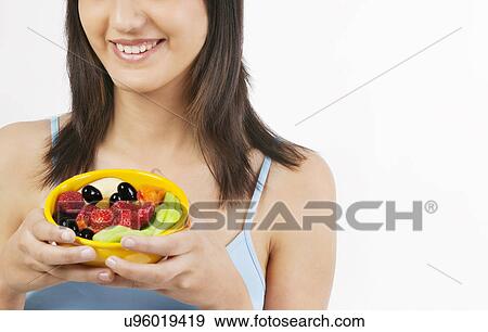 Stock Photo - Woman holding a bowl of fruits . Fotosearch