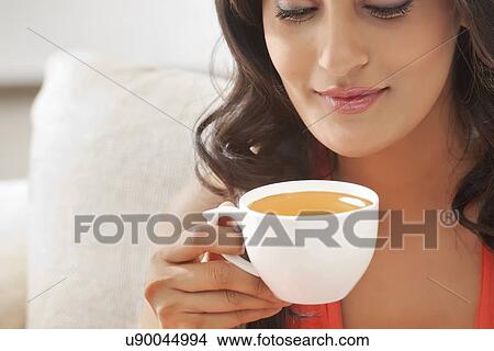 Woman holding a cup of coffee View Large Photo Image Picture - Woman holding a cup of coffee. Fotosearch