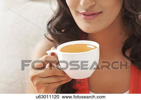 Woman holding a cup of coffee View Large Photo Image Stock Image - Woman holding a cup of coffee. Fotosearch