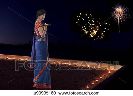 Stock Image - Woman holding a diya. Fotosearch