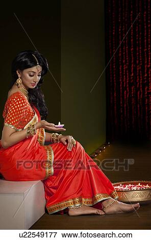 Woman holding a diya View Large Photo Image Stock Photo - Woman holding a diya. Fotosearch