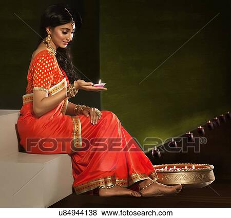 Woman holding a diya View Large Photo Image Stock Photo - Woman holding a diya. Fotosearch