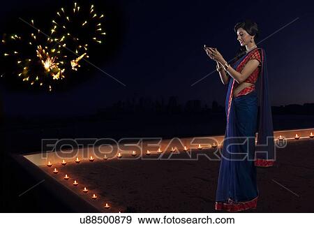 Woman holding a diya View Large Photo Image Stock Photo - Woman holding a diya. Fotosearch