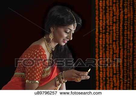 Woman holding a diya View Large Photo Image Stock Photo - Woman holding a diya. Fotosearch