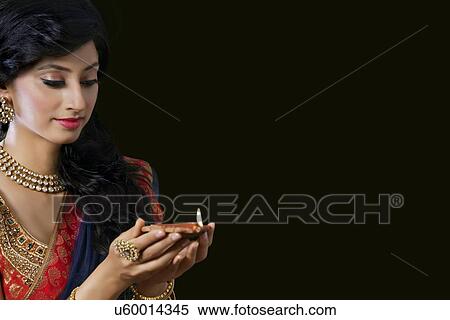 Woman holding a diya View Large Photo Image Stock Photography - Woman holding a diya. Fotosearch