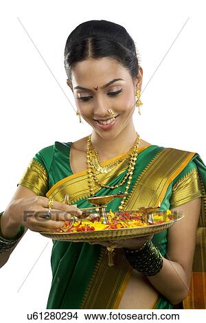 Picture - Woman holding a tray with diyas . Fotosearch