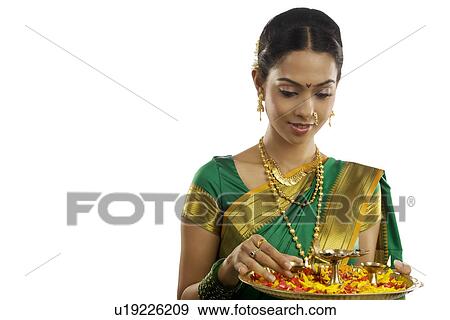 Stock Photo - Woman holding a tray with diyas . Fotosearch