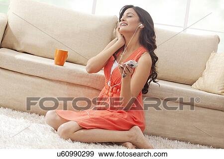 Woman listening to music on her mobile phone View Large Photo Image Stock Photo - Woman listening to music on her mobile phone. Fotosearch