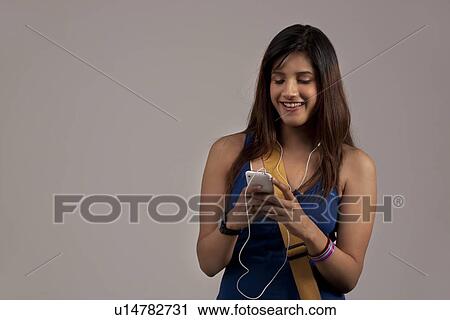 Woman listening to music on her phone View Large Photo Image Stock Image - Woman listening to music on her phone . Fotosearch