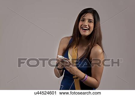 Woman listening to music on her phone View Large Photo Image Stock Image - Woman listening to music on her phone . Fotosearch