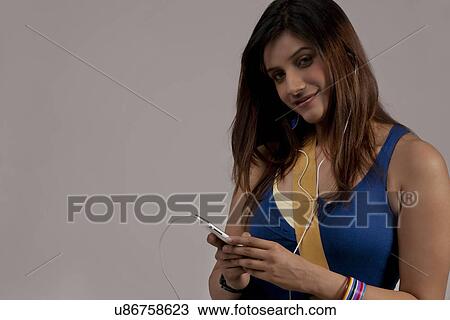 Stock Image - Woman listening to music on her phone . Fotosearch