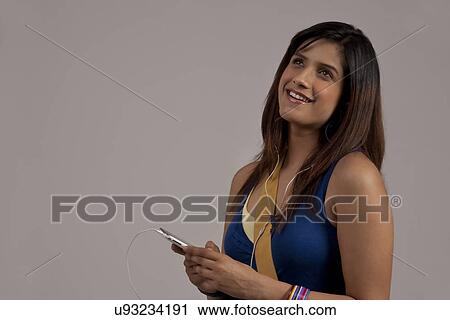 Stock Image - Woman listening to music on her phone . Fotosearch