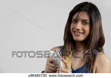 Stock Image - Woman listening to music on her phone . Fotosearch