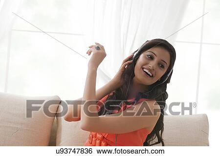 Woman listening to music View Large Photo Image Stock Photograph - Woman listening to music. Fotosearch