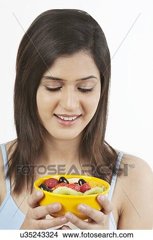 Woman looking at a bowl of fruits View Large Photo Image Picture - Woman looking at a bowl of fruits . Fotosearch