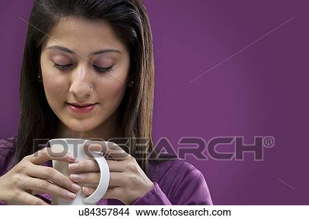 Woman looking at a cup of coffee View Large Photo Image Picture - Woman looking at a cup of coffee . Fotosearch