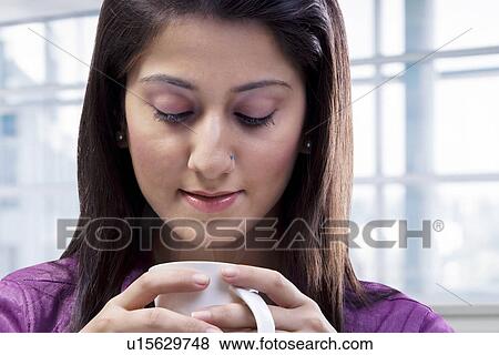 Woman looking at a cup of coffee View Large Photo Image Stock Photo - Woman looking at a cup of coffee . Fotosearch