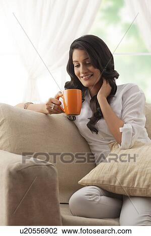 Woman looking at her mug of tea View Large Photo Image Stock Image - Woman looking at her mug of tea. Fotosearch