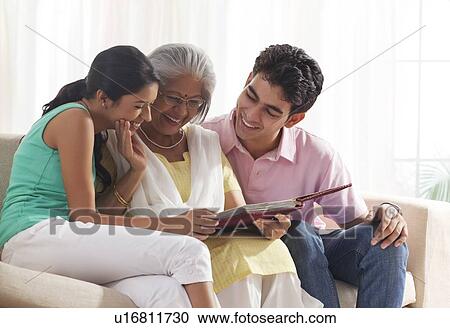 Woman looking at photo album with grandchildren View Large Photo Image Stock Image - Woman looking at photo album with grandchildren. Fotosearch