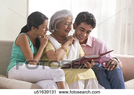 Woman looking at photo album with grandchildren View Large Photo Image Stock Image - Woman looking at photo album with grandchildren. Fotosearch