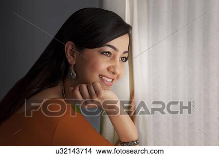 Woman looking out of a window View Large Photo Image Picture - Woman looking out of a window . Fotosearch