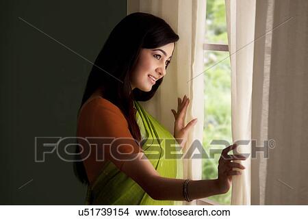 Picture - Woman looking out of a window . Fotosearch