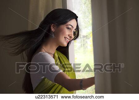 Woman looking out of a window View Large Photo Image Stock Image - Woman looking out of a window . Fotosearch