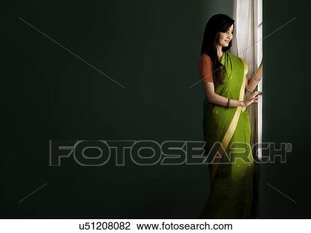 Woman looking out of a window View Large Photo Image Stock Image - Woman looking out of a window . Fotosearch