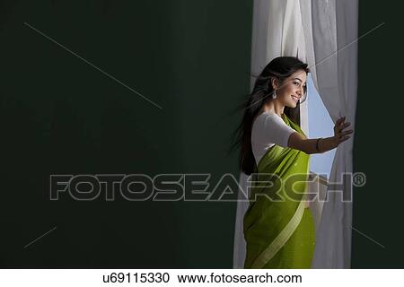 Stock Image - Woman looking out of a window . Fotosearch