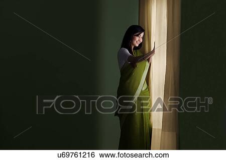 Stock Photograph - Woman looking out of a window . Fotosearch