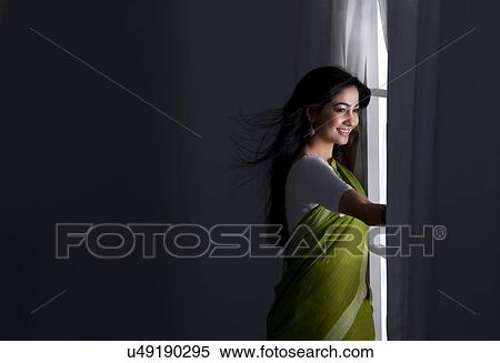 Woman looking out of a window View Large Photo Image Stock Photography - Woman looking out of a window . Fotosearch