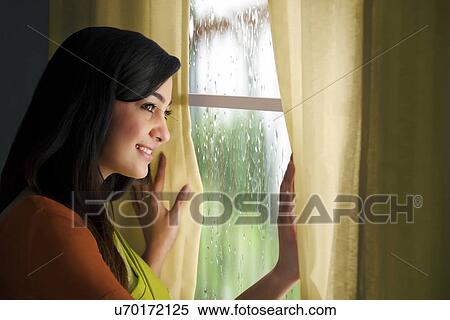 Stock Photography - Woman looking out of a window . Fotosearch