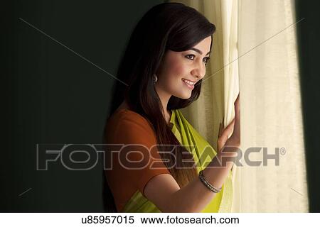 Woman looking out of a window View Large Photo Image Stock Photography - Woman looking out of a window . Fotosearch