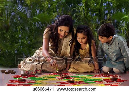 Woman making a rangoli with her kids View Large Photo Image Stock Image - Woman making a rangoli with her kids . Fotosearch