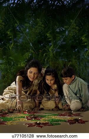 Woman making a rangoli with her kids View Large Photo Image Stock Photo - Woman making a rangoli with her kids . Fotosearch