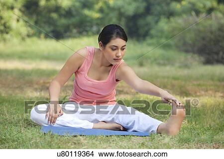 Picture - Woman on grass stretching . Fotosearch