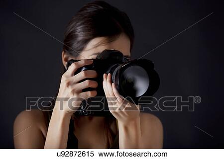 Woman photographer taking photograph against black background View Large Photo Image Stock Photography - Woman photographer taking photograph against black background . Fotosearch