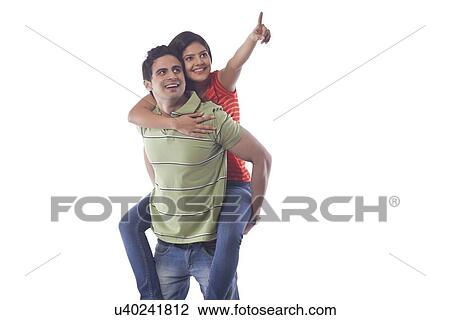 Woman pointing while getting a piggyback ride View Large Photo Image Stock Image - Woman pointing while getting a piggyback ride. Fotosearch