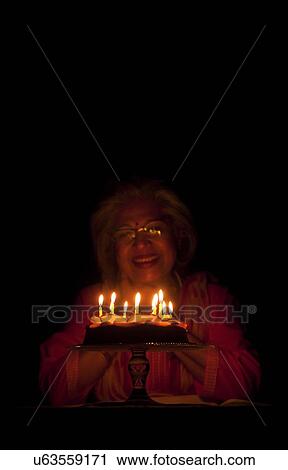 Stock Image - Woman posing with her birthday cake. Fotosearch