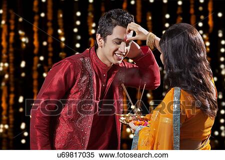 Stock Photography - Woman putting tika on a man. Fotosearch
