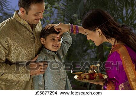 Woman putting tikka on her sons forehead View Large Photo Image Picture - Woman putting tikka on her sons forehead . Fotosearch