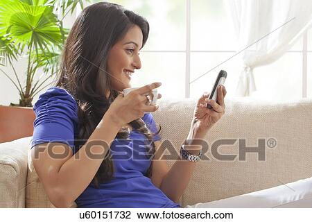 Woman reading an sms on a mobile phone View Large Photo Image Stock Image - Woman reading an sms on a mobile phone. Fotosearch